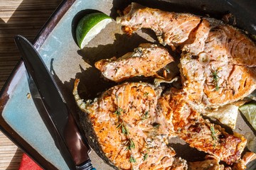 Delicious salmon steak grilled with lemon and pepper on a plate
