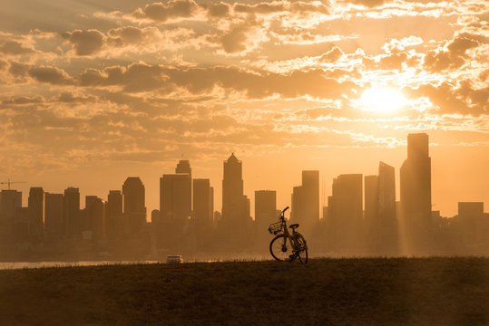 Bicycle waiting for a rider in Seattle with city skyline and ferry in background at sunrise