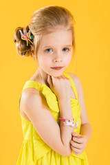 Girl posing on yellow background.