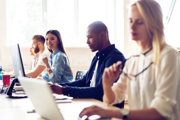 Fototapeta premium Confident and successful. Young modern colleagues in smart casual wear working while spending time in the office.