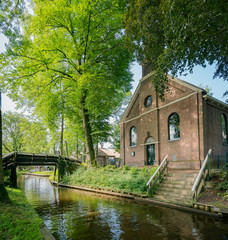 Fototapeta na wymiar Exterior view of a beautiful church with canal view at Giethoorn