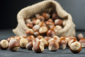 Hazelnuts, filbert in burlap sack on wooden backdrop. heap or stack of hazelnuts. Hazelnut background, healty food