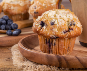 Closeup of a Blueberry Muffin on a Wooden Plate