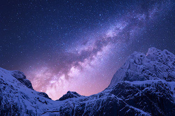 Obrazy na Szkle  Droga Mleczna nad ośnieżonymi górami. Przestrzeń. Fantastyczny widok na pokryte śniegiem skały i gwiaździste niebo w nocy w Nepalu. Grzbiet górski i niebo z gwiazdami w Himalajach. Krajobraz z fioletową drogą mleczną. Galaktyka