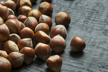 Obraz premium Hazelnuts on wooden backdrop. heap or stack of hazelnuts. Hazelnut background, healty food