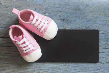 Cute little baby shoe on wood background