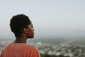 Woman looking out over the city - obrazy, fototapety, plakaty