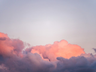 Gorgeous close up view of fluffy cumulus clouds with pink and purple hues resembling delicious...