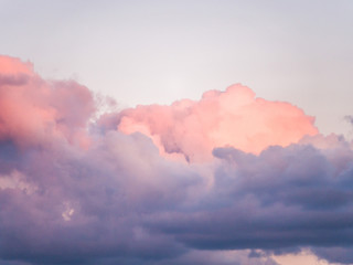 Gorgeous close up view of fluffy cumulus clouds with pink and purple hues resembling delicious mouthwatering cotton candy.