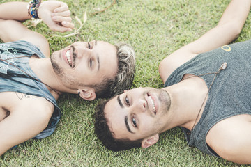casal gay deitado na grama