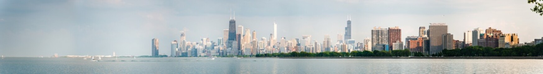 Gorgeous panoramic view of the Chicago skyline including new and old skyscrapers across the water of Lake Michigan.