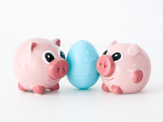 pink ceramic salt and pepper shakers in the shape of pigs with a light blue plastic Easter egg between them