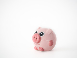 Close up photograph of a single pink round pig ceramic salt and pepper shaker isolated on a white background with space around the animal shaped object.