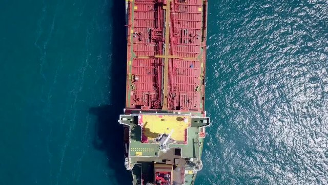 Aerial footage of a large crude oil tanker approaching a commercial port at the Mediterranean sea.