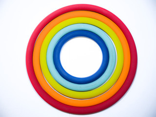 Beautiful abstract photograph of colorful circular ring shaped flexible silicone pot holders of various sizes and rainbow colors making a great background, backdrop or wallpaper image.