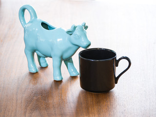 Close up view of a black porcelain or ceramic tea or coffee cup or mug and a blue or turquoise...