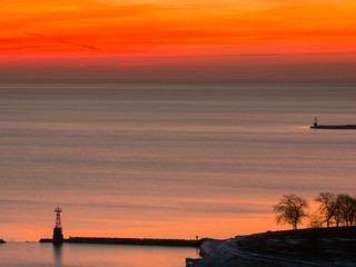 Beautiful landscape photograph of a vivid red orange and yellow sunrise in Chicago over the water...