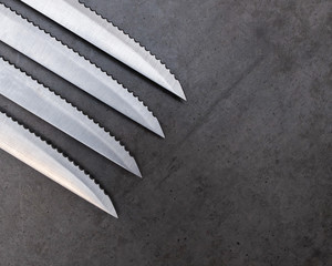 Serrated knives on a dark gray table