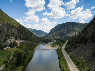Aerial panoramic view of a scenic road going through the valley surrounded by the Beautiful Canadian Mountains. Located between Hope and Princeton, BC, Canada.
