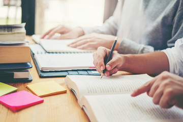 High school or college students studying and reading together in library