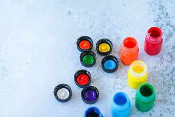 colorful Gouache or acrylic paints in jars on white grunge background, selective focus