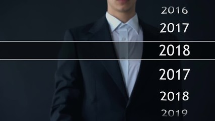 Businessman selects 2018 year in virtual menu, search for data, business history - Powered by Adobe