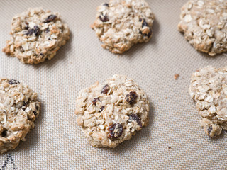 A closeup of a silicone baking mat full of oatmeal raisin Christmas holiday oatmeal raisin cookies