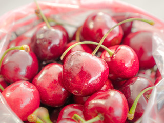 A closeup of a pile of red cherries with stems.