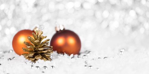 Christbaumkugeln in Orange mit Tannenzapfen und Perlen im Schnee, Header