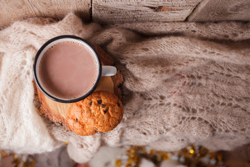 Cocoa with Cozy winter home background, cup of hot cacao with american cookies, warm knitted sweater on vintage wooden background, vintage tone, top vew, copy space. Lifestyle rustic nordic concept.