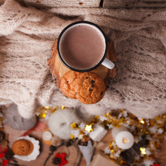 Obraz na płótnie Canvas Cocoa with Cozy winter home background, cup of hot cacao with american cookies, warm knitted sweater on vholiday decoration blur background, vintage tone, top vew, copy space. Lifestyle rustic nordic
