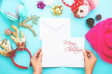 Woman open Christmas card with ornaments and gifts. Flat lay, top view