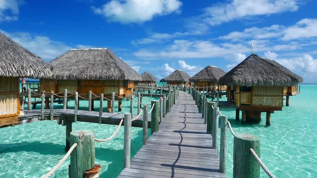 Luxury overwater villas on blue lagoon, white sandy beach and Otemanu mountain at Bora Bora island, Tahiti, French Polynesia
