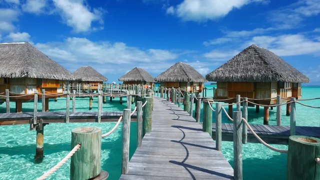Luxury overwater villas on blue lagoon, white sandy beach and Otemanu mountain at Bora Bora island, Tahiti, French Polynesia
