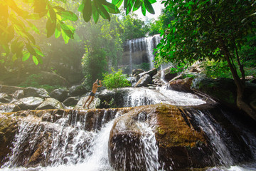 Boy is jumping into a waterfall in forest at Soo Da Cave Roi et Thailand
