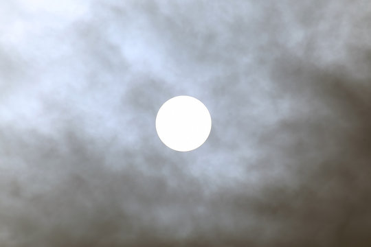 solar disk at noon through the clouds