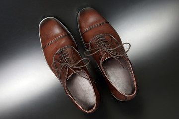 Classic men's brown Oxford shoes on dark background