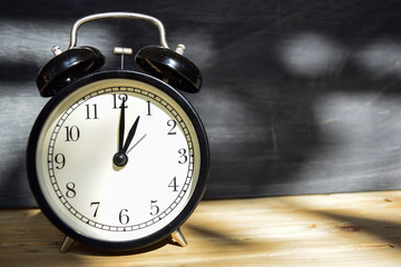 1 am/pm Back to school concept. Alarm clock on wooden with blackboard on background