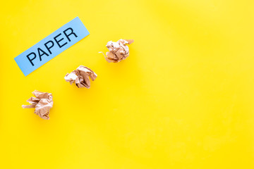 Waste suitable for recycle. Crumpled paper near printed word paper on yellow background top view copy space