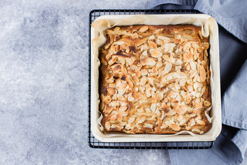 Top view of Homemade pies with apples and almond flakes. Norwegian Biscuit Pie on stone concrete table background. Scandinavia Kitchen