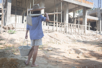 Little girl labor working in commercial building structure, World Day Against Child Labour concept.