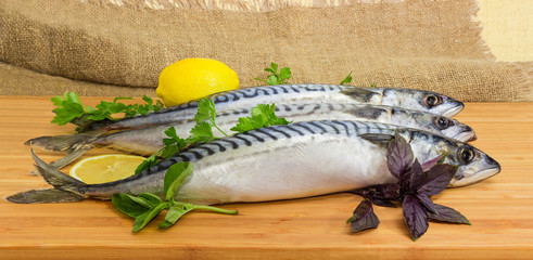 Unfrozen uncooked Atlantic mackerel on the bamboo wooden cutting board