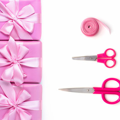 Rows of boxes six with gifts decoration ribbon satin bow scissors pink A top view of Flat lay