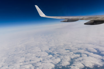 wing of an airplane flying above the clouds