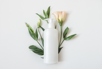 Natural organic cosmetic packaging plastic mock up with leaves and flowers. Mock-up bottle for...