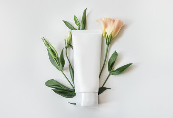 Natural organic cosmetic packaging plastic mock up with leaves and flowers. Mock-up bottle for branding and label.