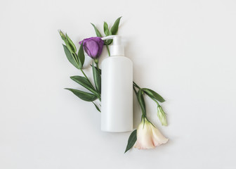 Natural organic cosmetic packaging plastic mock up with leaves and flowers. Mock-up bottle for branding and label.