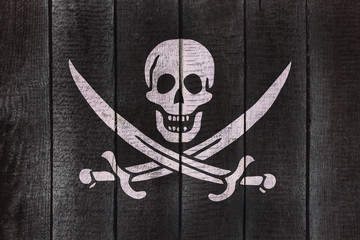 Calico Jack Pirate Flag on a wooden backgound. Pirates flags on wood texture.