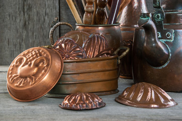 Vintage copper molds on a wooden gray background.