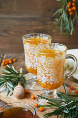 Tea with sea buckthorn and honey on a wooden background